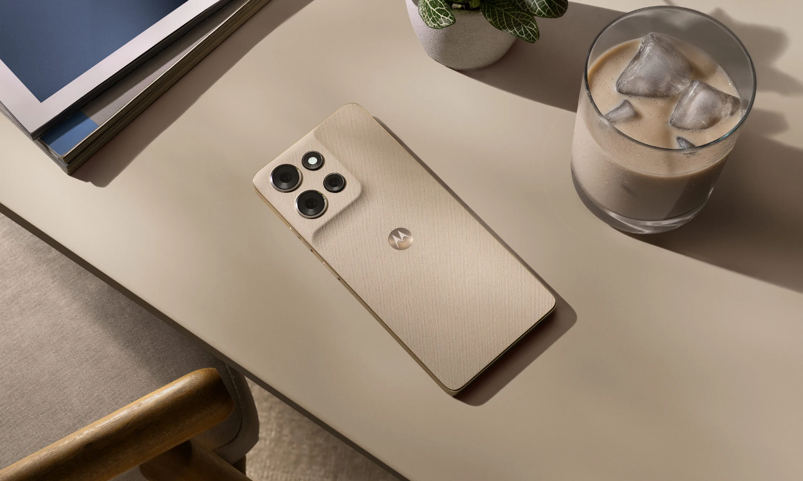 moto g power 2026 on a desk, next to an iced coffee