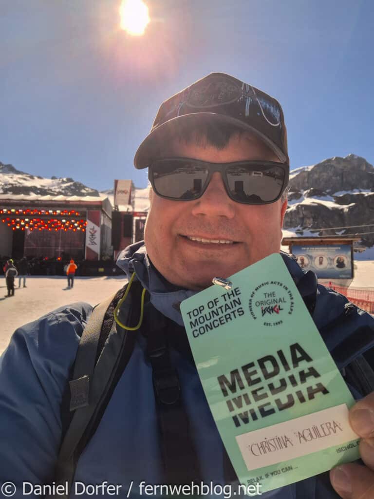 Reiseblogger Daniel Dorfer mit Media-Badge vor der noch leeren Bühne auf der Idalp beim Top of the Mountain Closing Concert 2026