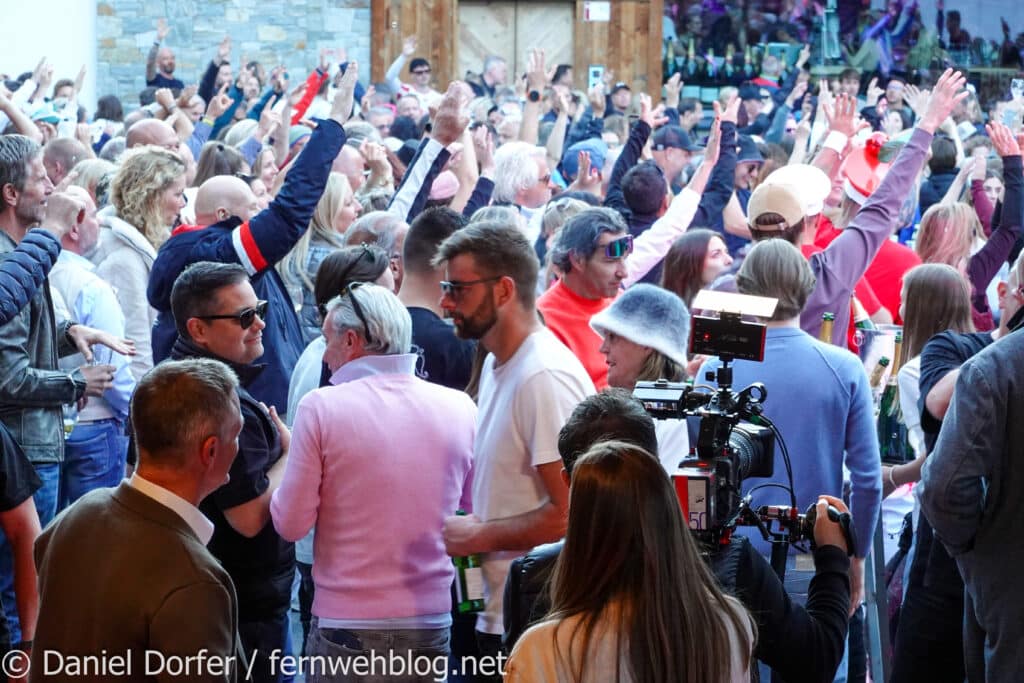 Feiernde Crowd mit erhobenen Händen vor der Bühne an der Trofana Alm in Ischgl beim Saisonfinale 2026