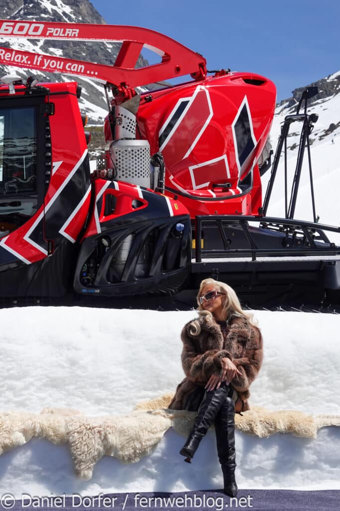 Christina Aguilera im Pelzmantel vor roter Pistenraupe beim Pic in the Snow Ischgl 2026