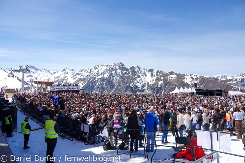 Blick auf den Fotograben und das Publikum mit Bergkulisse beim Top of the Mountain Closing Concert 2026 in Ischgl