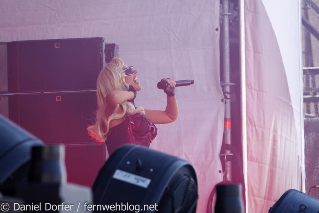 Christina Aguilera lachend mit Mikro auf der Bühne beim Top of the Mountain Closing Concert 2026 in Ischgl