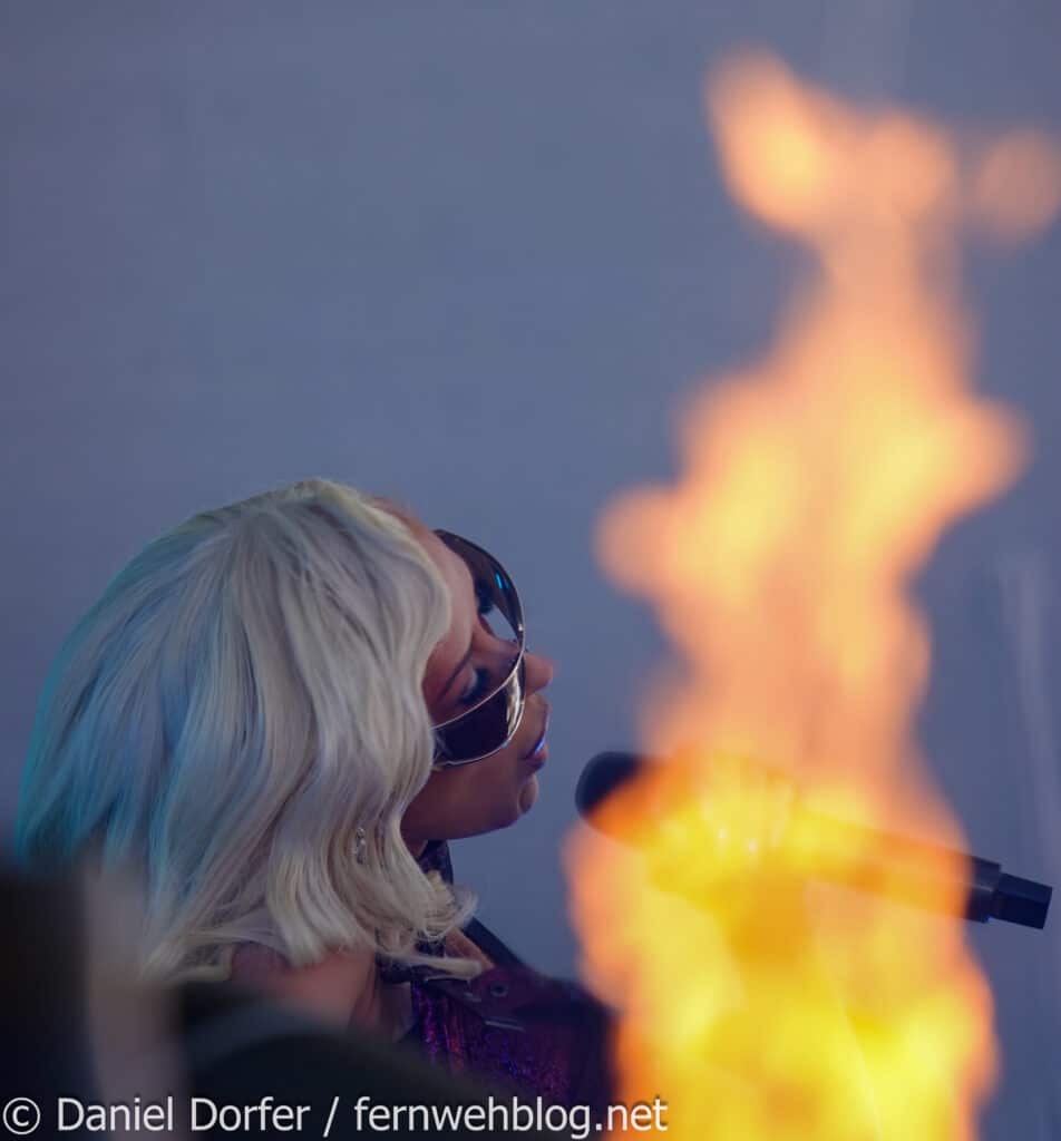 Christina Aguilera im Profil hinter Pyrotechnik-Flamme beim Top of the Mountain Closing Concert 2026 Ischgl