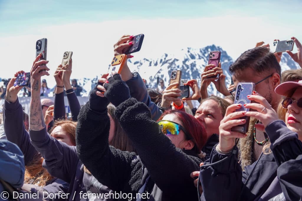 Fans halten ihre Handys hoch und filmen das Konzert vor Bergkulisse beim Saisonfinale Ischgl 2026