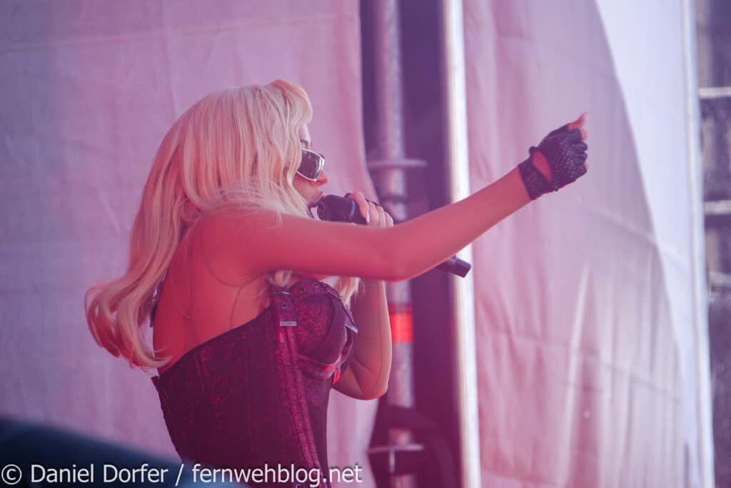 Christina Aguilera mit Mikro und Zeigegeste auf der Bühne beim Top of the Mountain Closing Concert 2026 Ischgl
