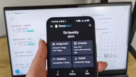 donetick site on a phone with laptop in background