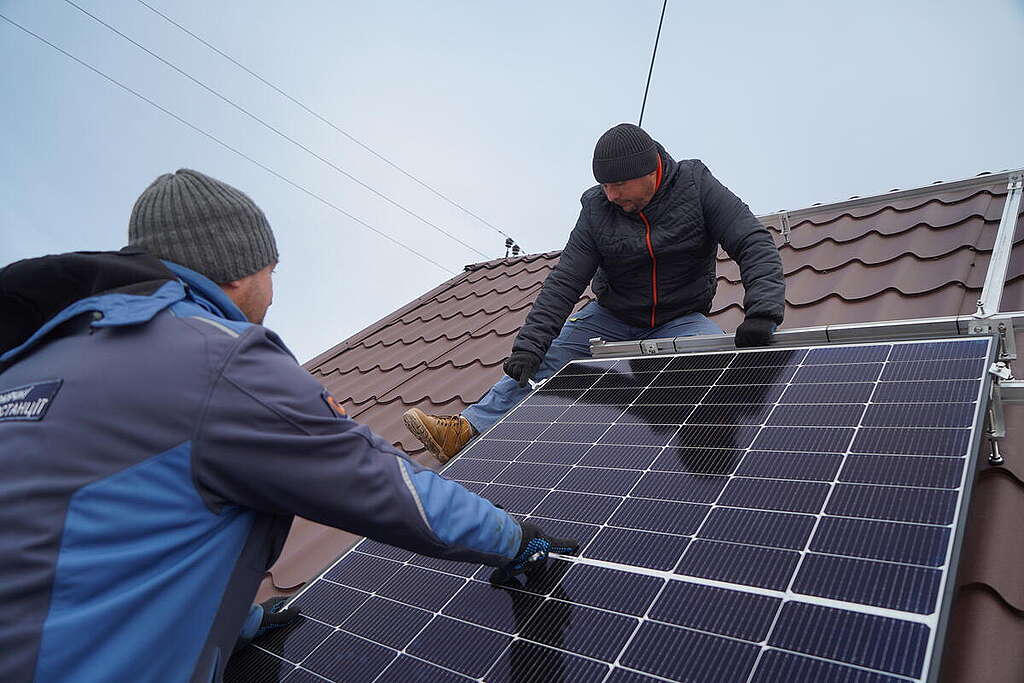 Fitting solar panels on roof of a War-Torn Hospital in Ukraine as part of green reconstruction efforts. © Oleksandr Popenko / Greenpeace