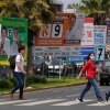 Pedestrians pass election campaign signs for presidential and congressional candidates, before the weekend's election in Lima, Peru, April 10, 2026.