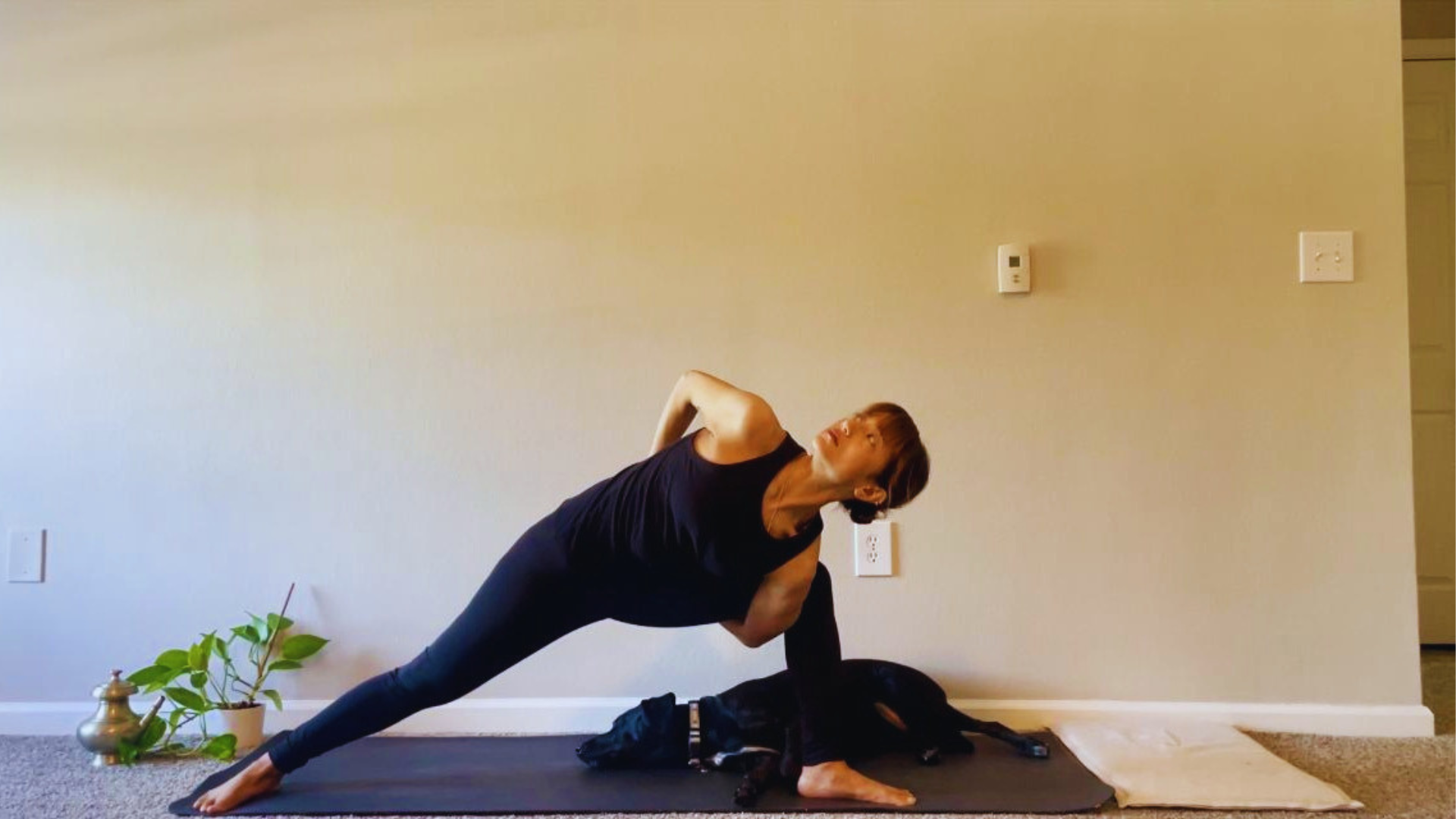 Woman with her arms in a yoga bind behind her back in the yoga pose Extended Side Angle 