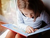 young girl reading picture book