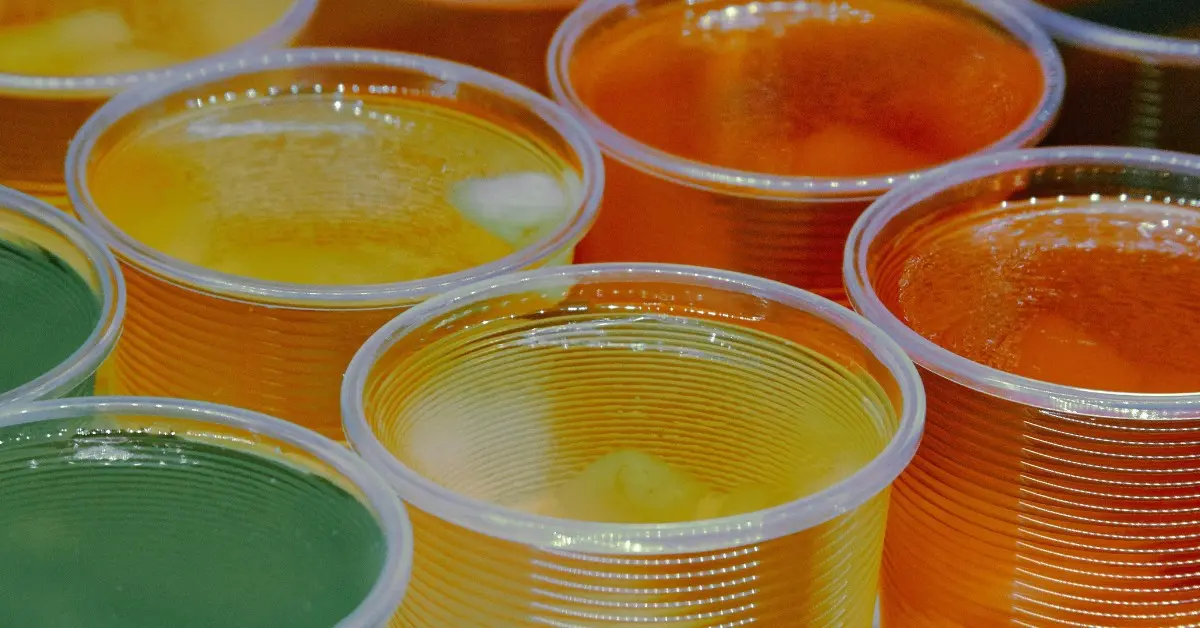 A line of brightly colored Jell-O cups in green, yellow, and orange