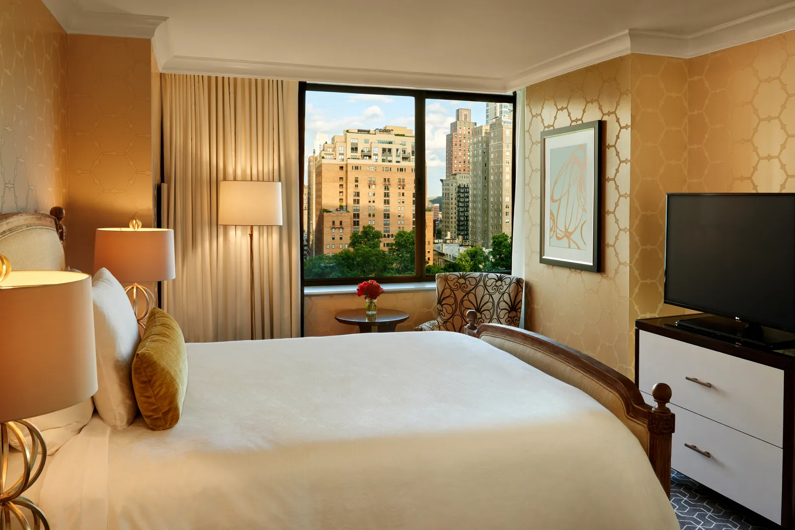 A dimly lit hotel room with a wide view of Philadelphia Buildings