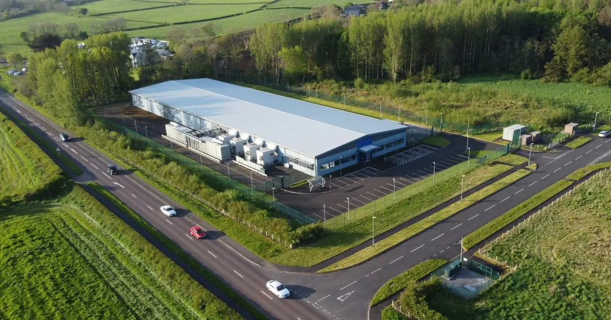 An ariel view of a white data center in the middle of farm land