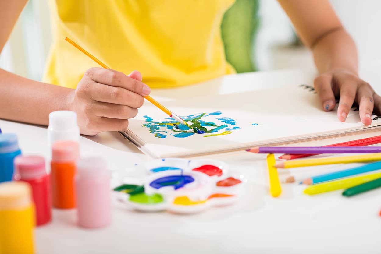 50+ Easy Travel Journal Ideas and Writing Prompts for Kids 3 Journal prompts and travel sketch ideas - Child painting with acrylics and watercolors