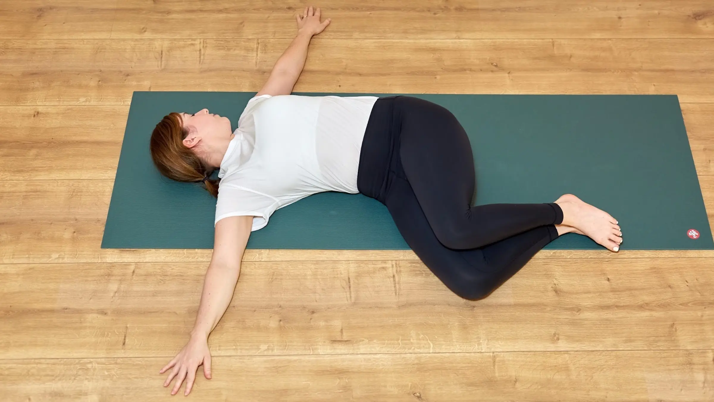 A woman in Reclining Twist, a yin yoga pose