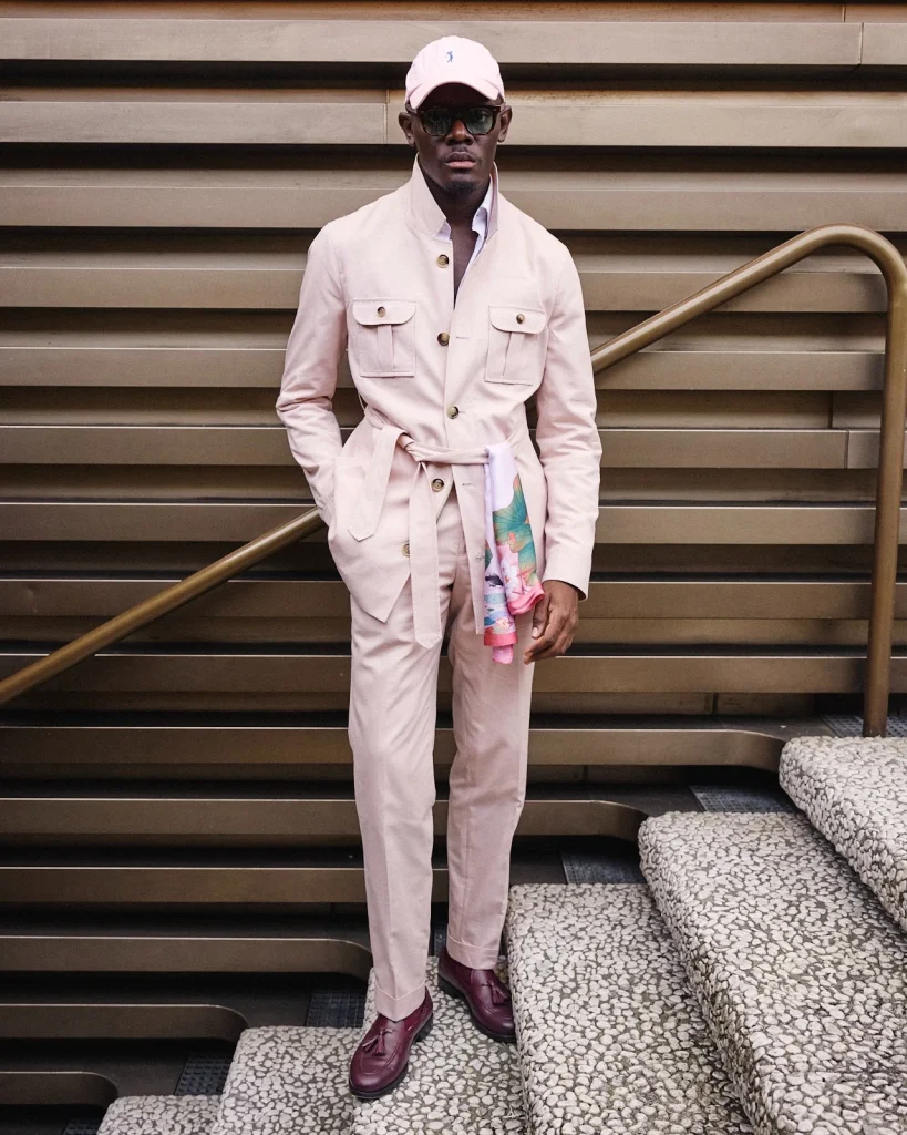 mens lapeled field jacket with pink pleated trousers and white linen shirt