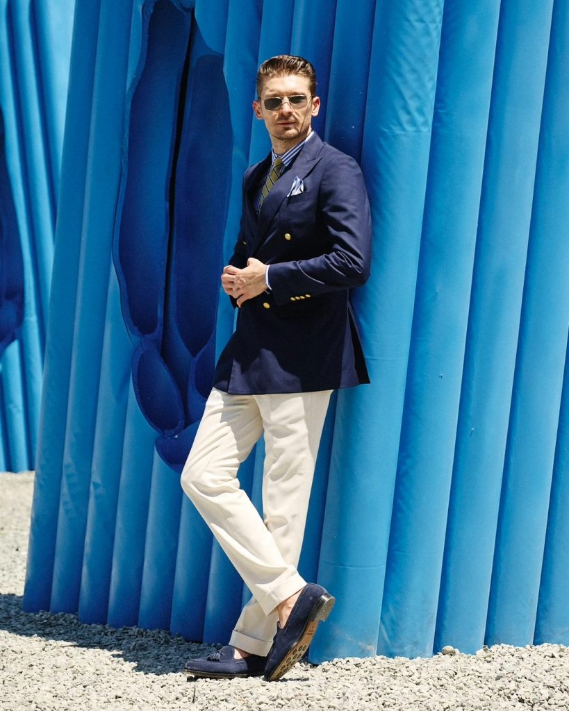 mens navy double breasted blazer with cream pleated trousers and striped shirt