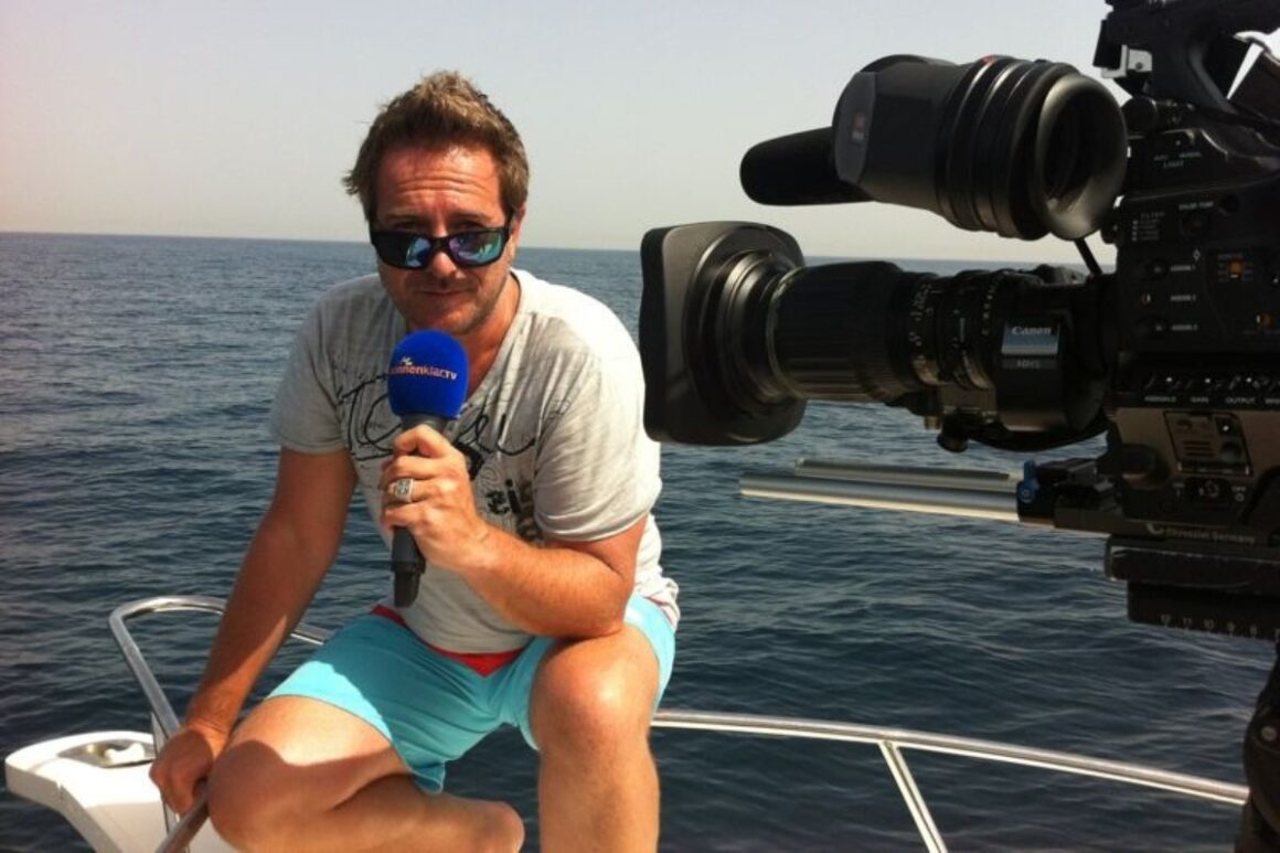 Kai Pätzmann moderiert auf einem Schiff, daneben Kamera in Nahaufnahme