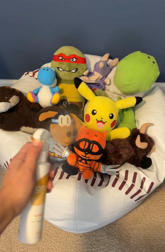 Besprühen Sie eine Sammlung von Plüschtieren, darunter Pikachu und andere Charaktere, auf einem Sitzsack mit ungiftigem Luft- und Stoffspray von Grow Fragrance