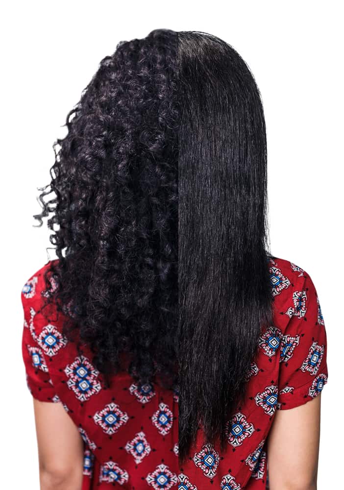 Back view of a woman's hair split down the middle, curly natural texture on one side and straight processed hair on the other, illustrating two different hair textures.