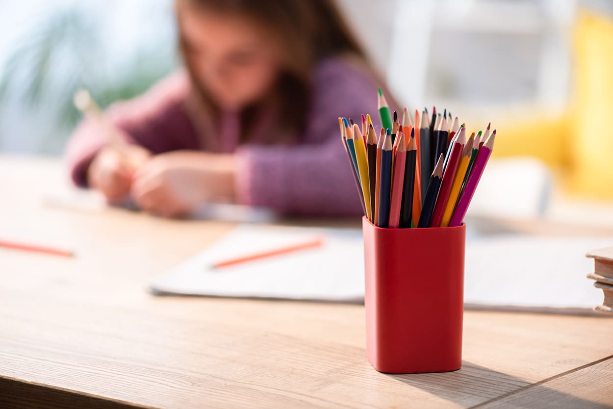 50+ Easy Travel Journal Ideas and Writing Prompts for Kids 2 Child drawing in a journal with colored pencils