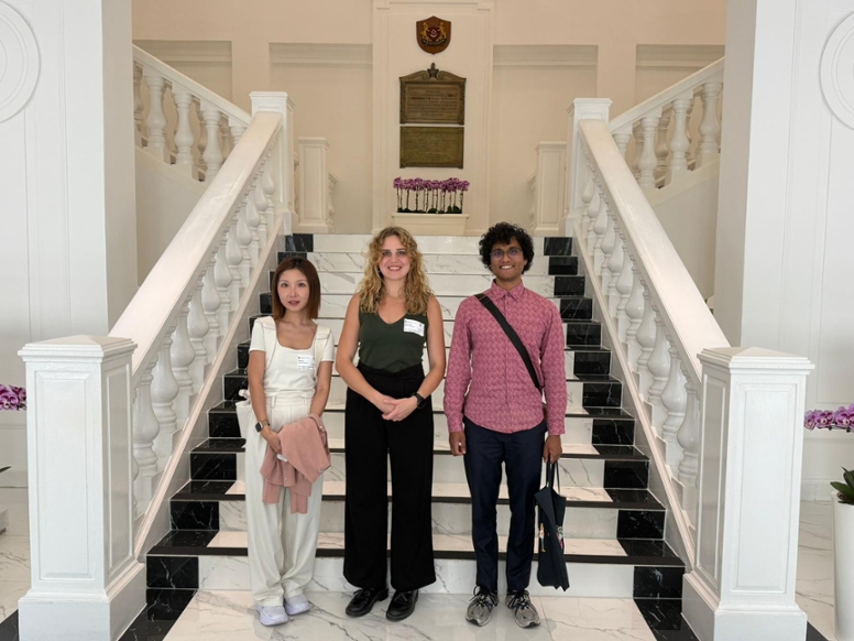 Foto 3: Die beiden RKI-Forschenden stehen gemeinsam mit ihrer Partnerin von der National University of Singapore in der Eingangshalle des singapurischen Gesundheitsministeriums.